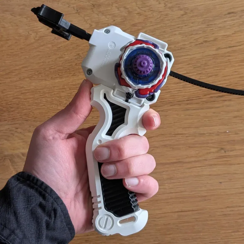 Bottom view of 3D printed Bakuten-style Beyblade X grip in hand with a beyblade loaded