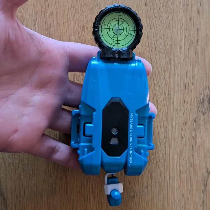 A beyblade X winder launcher with the leveling scope mounted