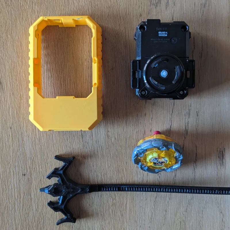 Bottom view of disassembled Beyblade X launcher grip showing mounting structure and internal fitment